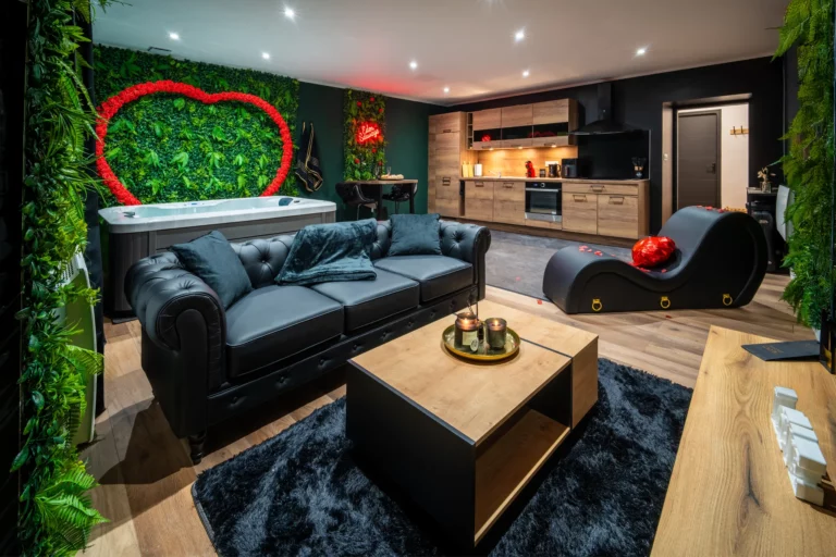 Salon avec canapé chesterfield et jacuzzi de la love room Eden Sauvage – photo LLP Agency