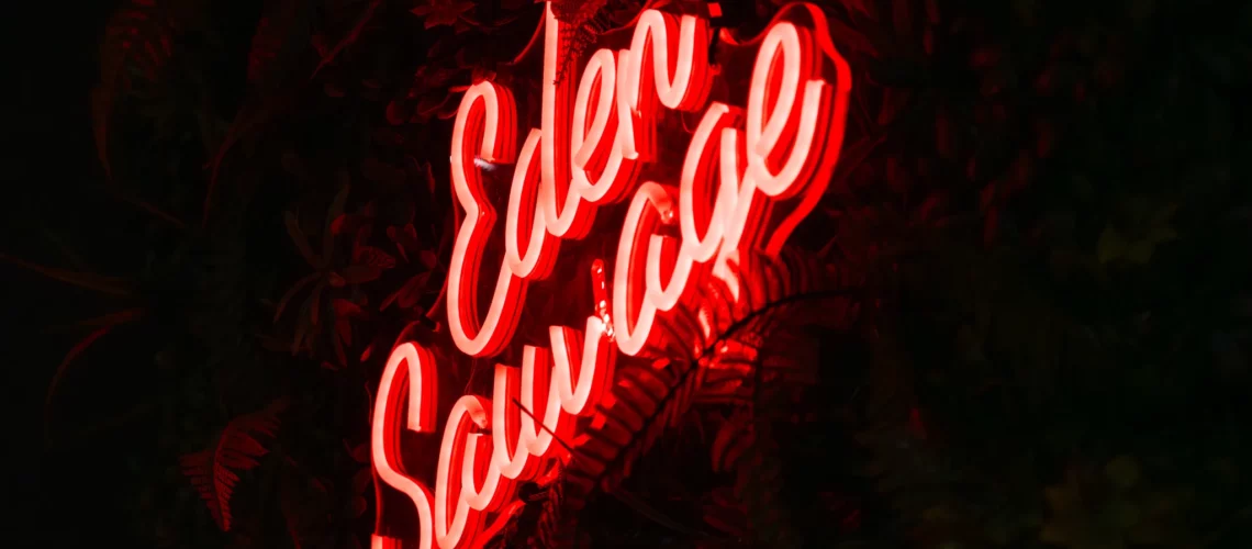 Enseigne néon Eden Sauvage sur mur végétal – photo LLP Agency